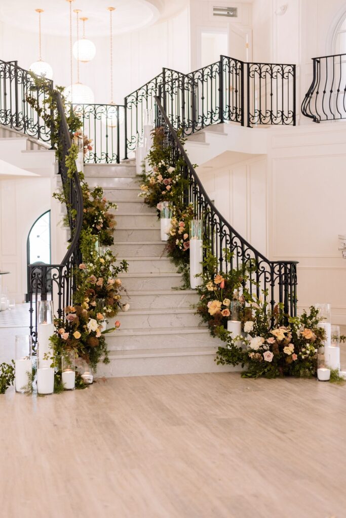 Archway Manor grand staircase with florals and candles