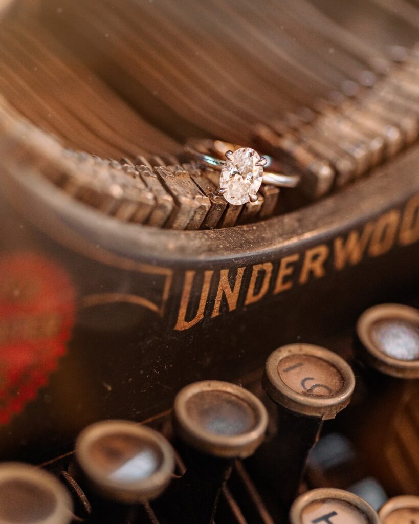 A close up shot of an engagement ring on a vintage typewriter in Pages on Kensington