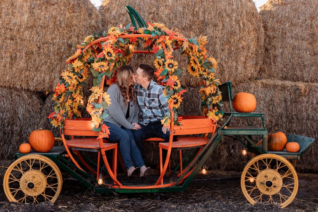 Couple kissing in a pumpkin carriage at the Calgary Farmyard