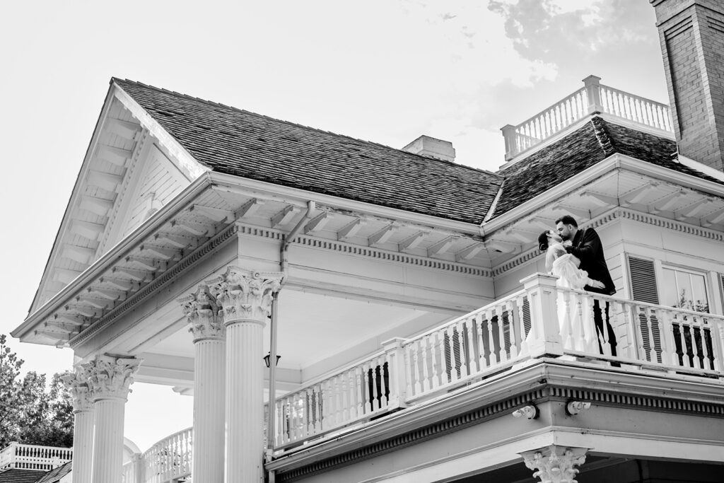 Bride and groom kissing on the balcony of the Norland Historic Estate