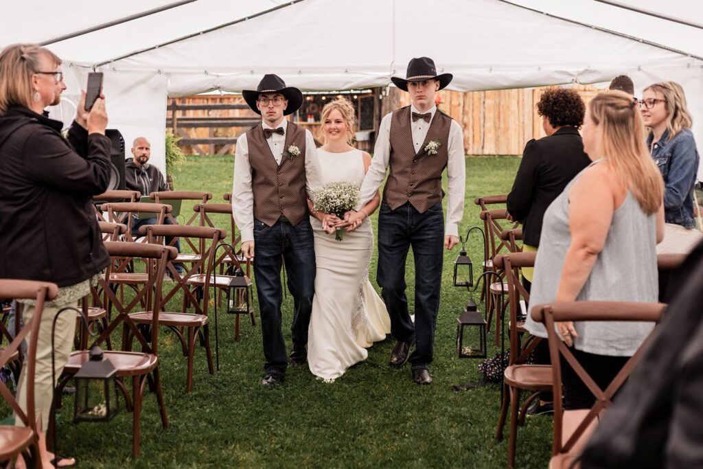 Bride being walked down the aisle by her sons