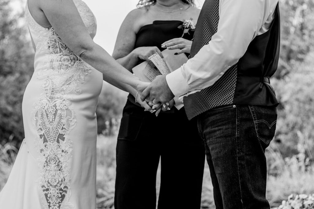 Closeup of bride and groom holding hands during ceremony