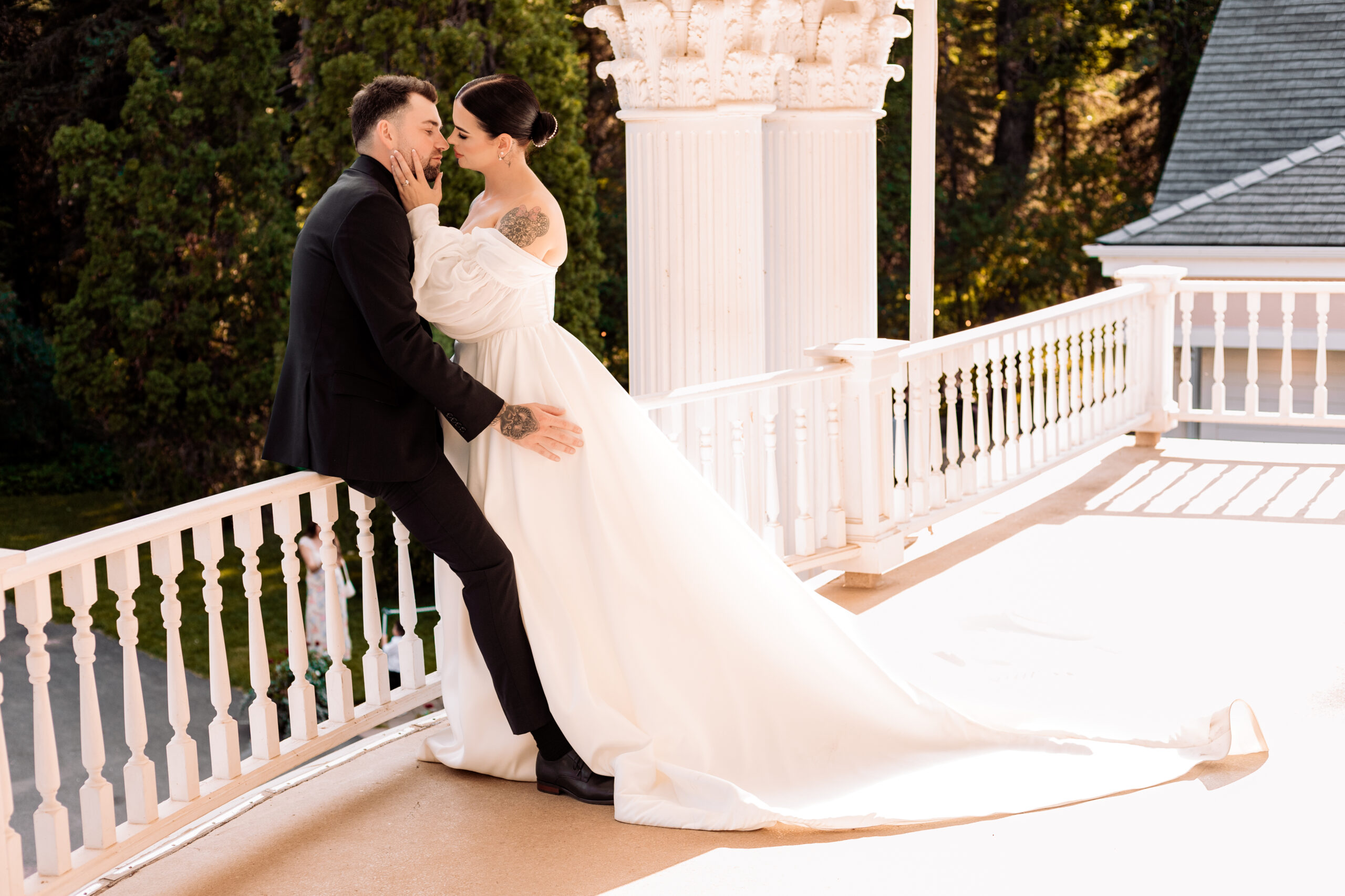 Bride and groom leaning in for a kiss on the balcony of the Norland Historic Estate