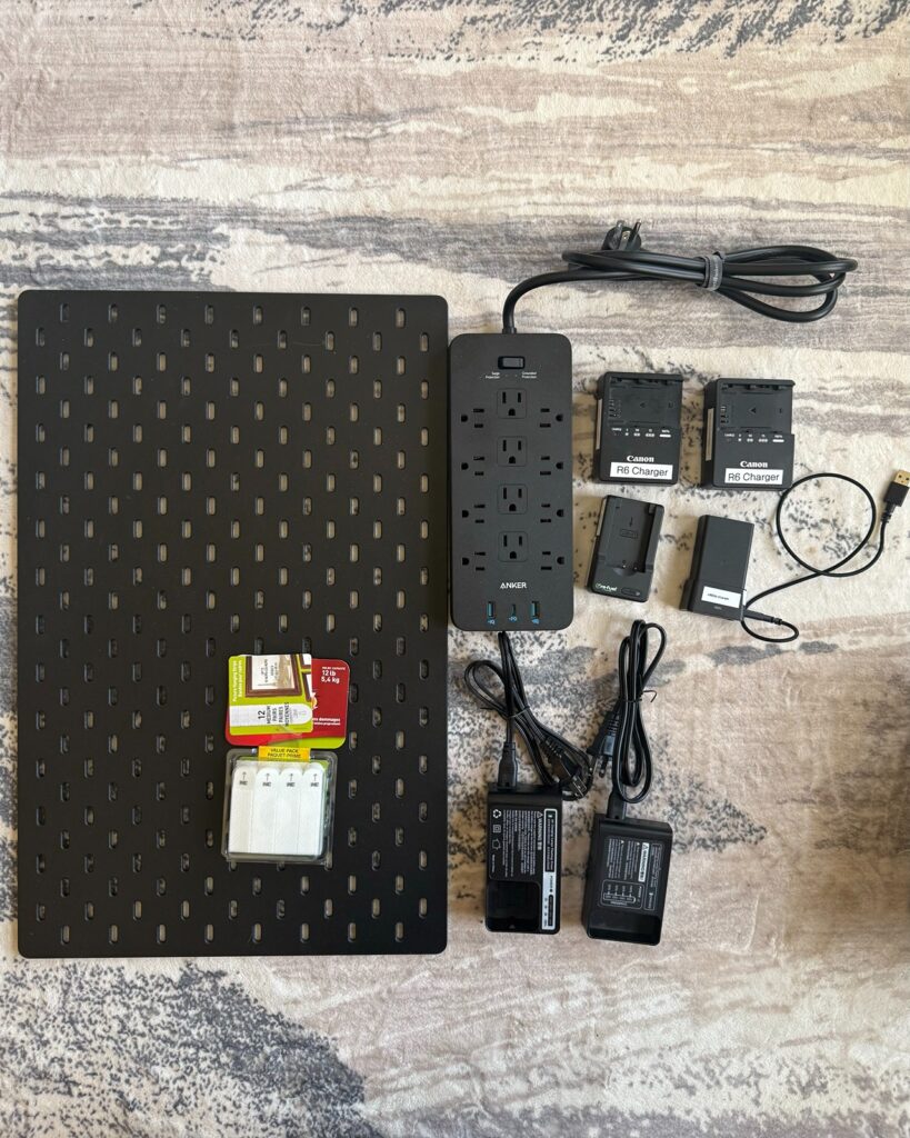 Pegboard with camera chargers laying on the floor