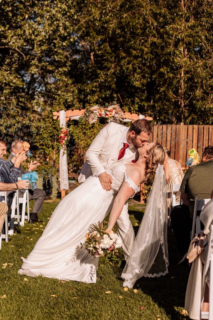mid aisle dip kiss during a calgary zoo wedding ceremony