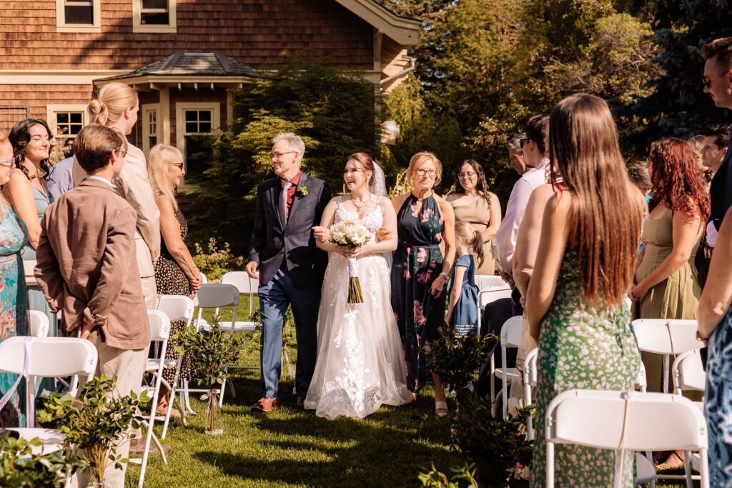 Bride walks down the aisle with her parents at her wedding at Reader Rock Garden