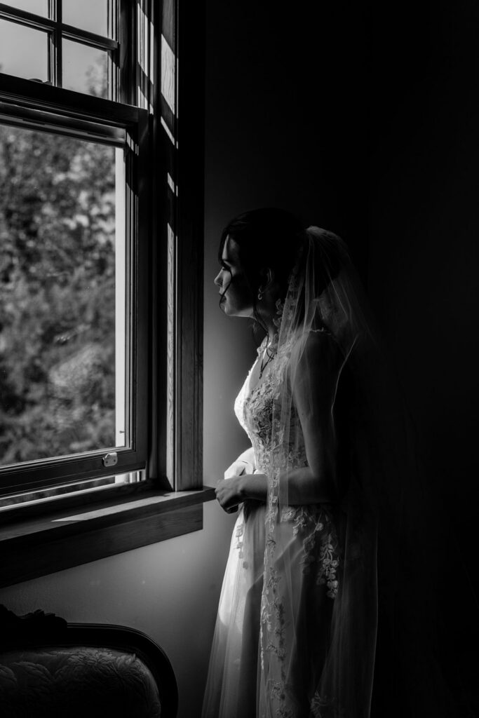 Bride watching guests arrive to her Reader Rock Garden wedding from the bridal room