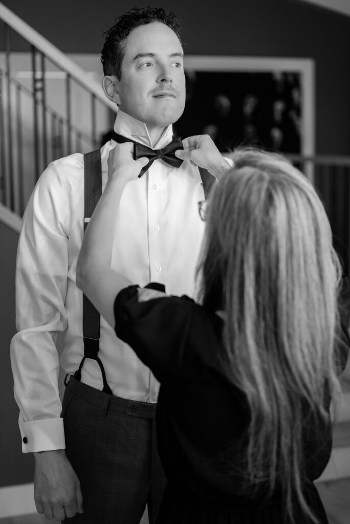 Groom having his bowtie adjusted
